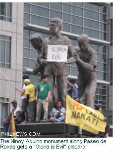 The Ninoy Aquino monument along Paseo de Roxas gets a "Gloria is Evil" placard