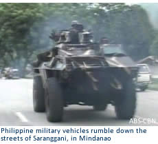 Philippine military vehicles rumble down the streets of Saranggani, in Mindanao.
