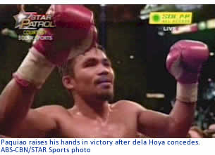 Paquiao raises his hands in victory after dela Hoya concedes.
