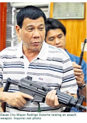 Davao City Mayor Rodrigo Duterte testing an assault weapon