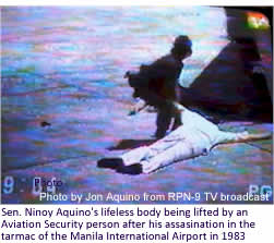 Sen. Ninoy Aquino's lifeless body being lifted by an Aviation Security person after his assasination in the tarmac of the Manila International Airport in 1983