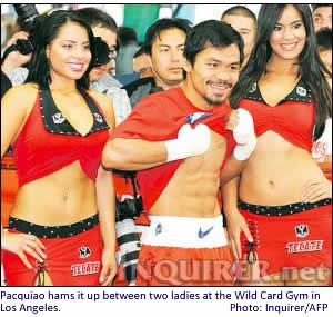 Pacquiao hams it up between two ladies at the Wild Card Gym in Los Angeles