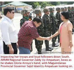 Inspecting her troops and loyal followers down South. ARMM Regional Governor Zaldy Uy Ampatuan, bows as he shakes Gloria Arroyo's hand, with Maguindanao Provincial Governor Sajid IslamUy Ampatuan looking on