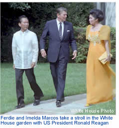 Ferdie and Imelda Marcos take a stroll in the White House garden with US President Ronald Reagan