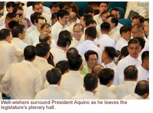 Well-wishers surround President Aquino as he leaves the legislature's plenary hall