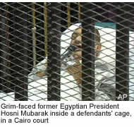 Grim-faced former Egyptian President Hosni Mubarak inside a defendants' cage, in a Cairo court