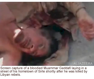 Screen capture of a bloodied Muammar Gaddafi laying in a street of his hometown of Sirte shortly after he was killed by Libyan rebels