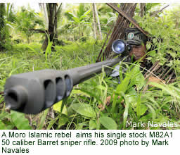 A Moro Islamic Liberation Front (MILF) rebel aims his single stock M82A1 50 caliber Barret sniper rifle. 2009 photo by Mark Navales