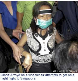 Gloria Arroyo on a wheelchair attempts to get on a night flight to Singapore