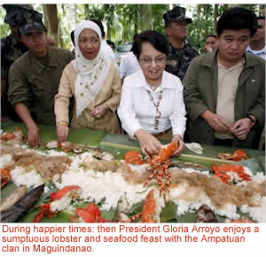 During happier times: then President Gloria Arroyo enjoys a sumptuous lobster and seafood feast with the Ampatuan clan in Maguindanao