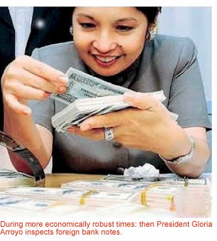 During more economically robust times: then President Gloria Arroyo inspects foreign currency bank notes