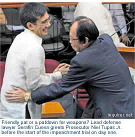 Friendly pat or a patdown for weapons? Lead defense lawyer Serafin Cueva greets Prosecutor Niel Tupas Jr. before the start of the impeachment trial on day one