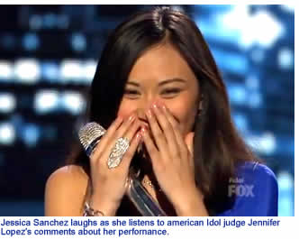 Jessica Sanchez laughs as she listens to american Idol judge Jennifer Lopez's comments about her perfornance