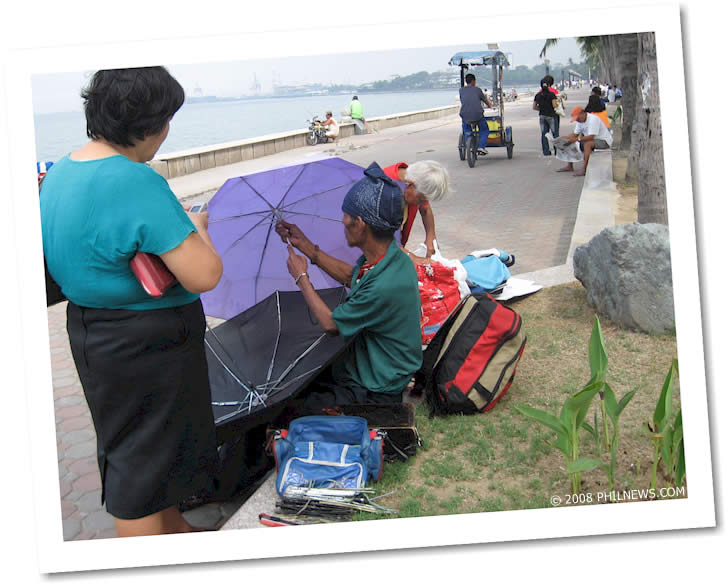 Picture of the week - The Umbrella Repairman: Keeping customers dry along Roxas Blvd.
