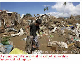 A young boy retrieves what he can of his family's household belongings